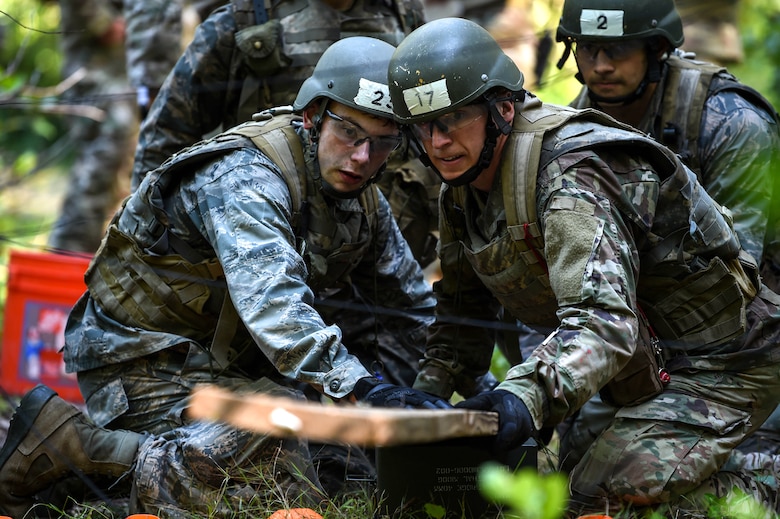 A team of tactical air control party (TACP) officer candidates work on solving the task of getting supplies over a simulated river without setting off simulated trip wires after navigating themselves to the given coordinates during the TOPT selection course phase II, Joint Base Lewis-McChord, Wash., Aug. 27, 2019. Candidates were evaluated on their performance under high levels of stress by experienced TACP officer and enlisted cadre, as well as Air Force psychologists throughout the week-long selection process.