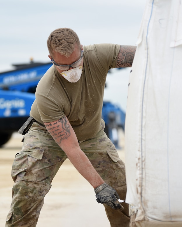 Staff Sgt. Matthew Thornton, 51st Civil Engineer Squadron structural craftsman, cuts open a bag of specialized concrete mix during the 51st CES’ biannual rapid airfield damage repair training on Osan Air Base, Republic of Korea, September 12, 2019. Over the course of a week, the squadron gets classroom training, time to practice and conduct a full-on execution of repairing a damaged airfield. (U.S. Air Force photo by Senior Airman Denise M. Jenson)