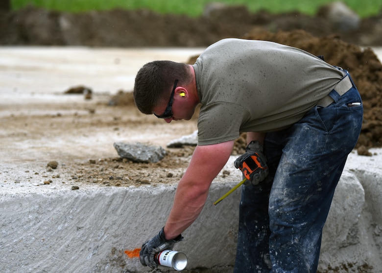 Squadron heavy equipment operator, marks inside a simulated crater during the 51st CES’ biannual rapid airfield damage repair training on Osan Air Base, Republic of Korea, September 12, 2019. When repairing a damaged airfield, there are two layers of concrete that need to be leveled and set in order for the airfield to be back to mission ready. (U.S. Air Force photo by Senior Airman Denise M. Jenson)