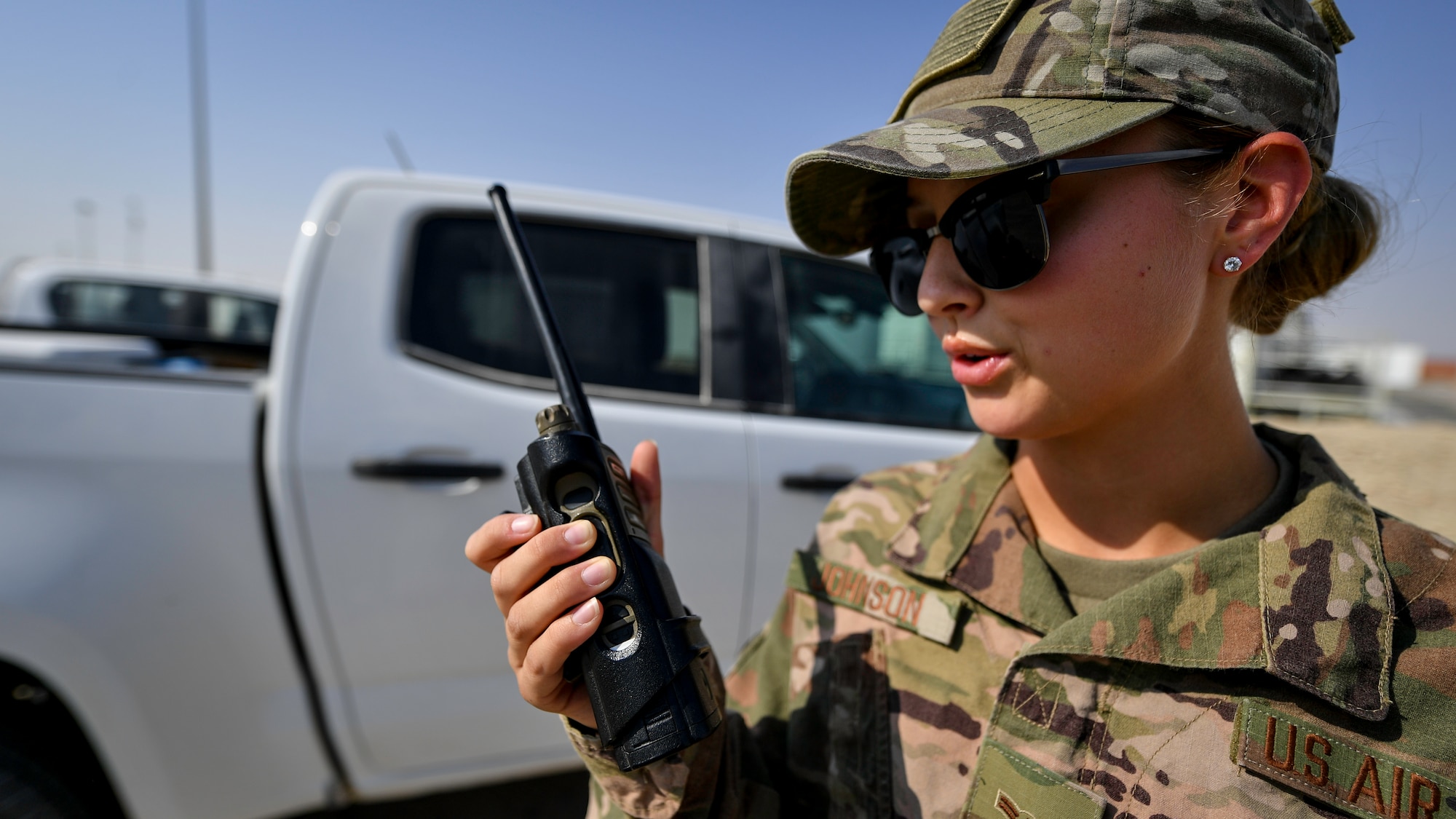 U.S. Air Force Airman 1st Class Page Johnson, 386th Civil Engineering Squadron force protection escort, radios dispatch at Ali Al Salem Air Base, Kuwait, Sept. 4, 2019. The force protection flight provides a security buffer between other country nationals such as contractors, their employees and the general base population. Airmen assist and escort OCNs during their duty day, help minimize potential data collection, and ensure departure of vehicles and personnel once their services are completed for the day. (U.S. Air Force photo by Staff Sgt. Mozer O. Da Cunha)