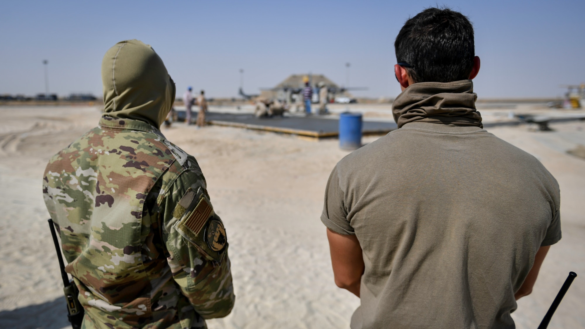 Airmen assigned to the 386th Expeditionary Civil Engineer Squadron observe contractors building an addition to the flightline at Ali Al Salem, Kuwait, Sept. 4, 2019. The force protection flight provides a security buffer between other country nationals such as contractors, their employees and the general base population. Airmen assist and escort OCNs during their duty day, help minimize potential data collection, and ensure the departure of vehicles and personnel once their services are completed for the day. (U.S. Air Force photo by Staff Sgt. Mozer O. Da Cunha)