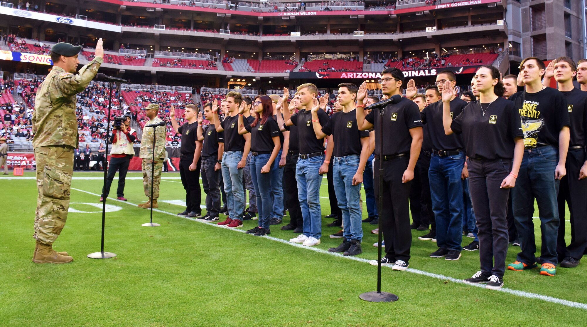 group of young men and women holding up their right hand to take an oath of enlistment.