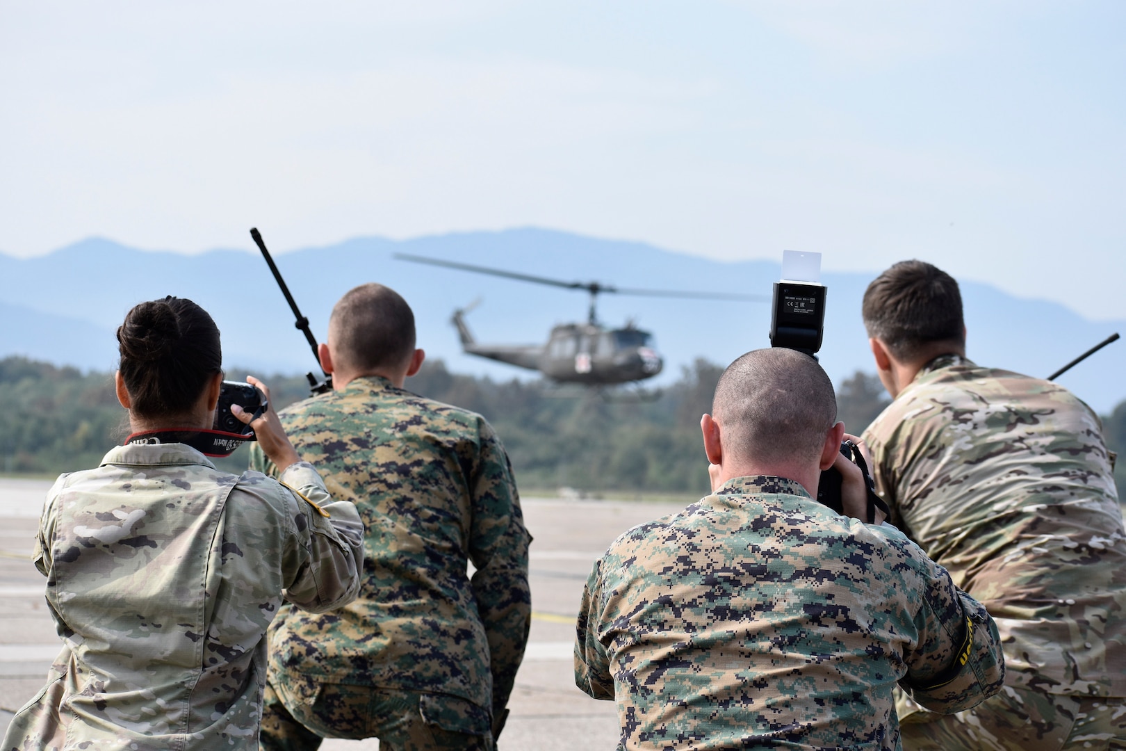 Members of a combined joint media information center team photograph a U.S. Air Force joint terminal attack controller training an Armed Forces of Bosni-Herzegovina service member in JTAC operations Sept. 11, 2019, at Tuzla International Airport, BiH during the Silver Arrow training event.