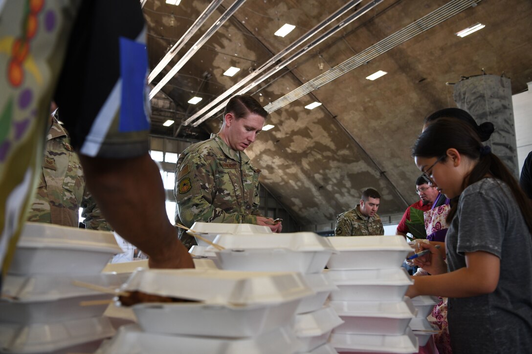 Airmen buy food from a table during a Diversity Day event at Ellsworth Air Force Base, S.D., Aug. 16, 2019. There are nine congressionally mandated heritage events and the 28th Bomb Wing Equal Opportunity Office and the Diversity Council host events for each of them to celebrate their heritage and what makes their culture special. (U.S. Air Force photo by Senior Airman Thomas Karol)
