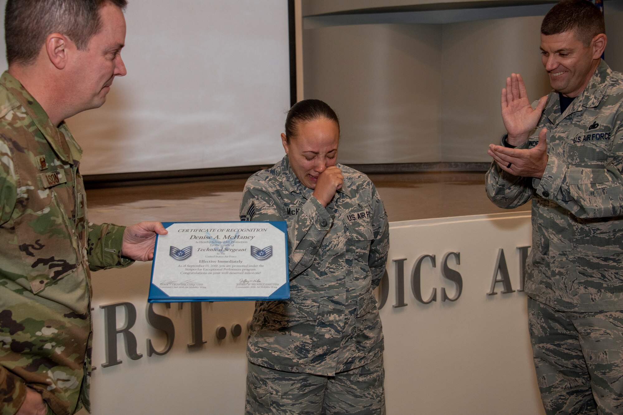 U.S. Air Force Col. Jeffrey Nelson, left, 60th Air Mobility Wing commander, and Chief Master Sgt. Derek Crowder, right, 60th AMW command chief, present Staff Sgt. Denise McHaney, 60th Aerospace Medicine Squadron public health supervisor with her Stripes for Exceptional Performers certificate for technical sergeant Sept. 13, 2019, at David Grant USAF Medical Center, Travis Air Force Base, California. The STEP promotion program offers commanders a limited opportunity to immediately promote enlisted members to staff sergeant or technical sergeant. (U.S. Air Force photo by Heide Couch)