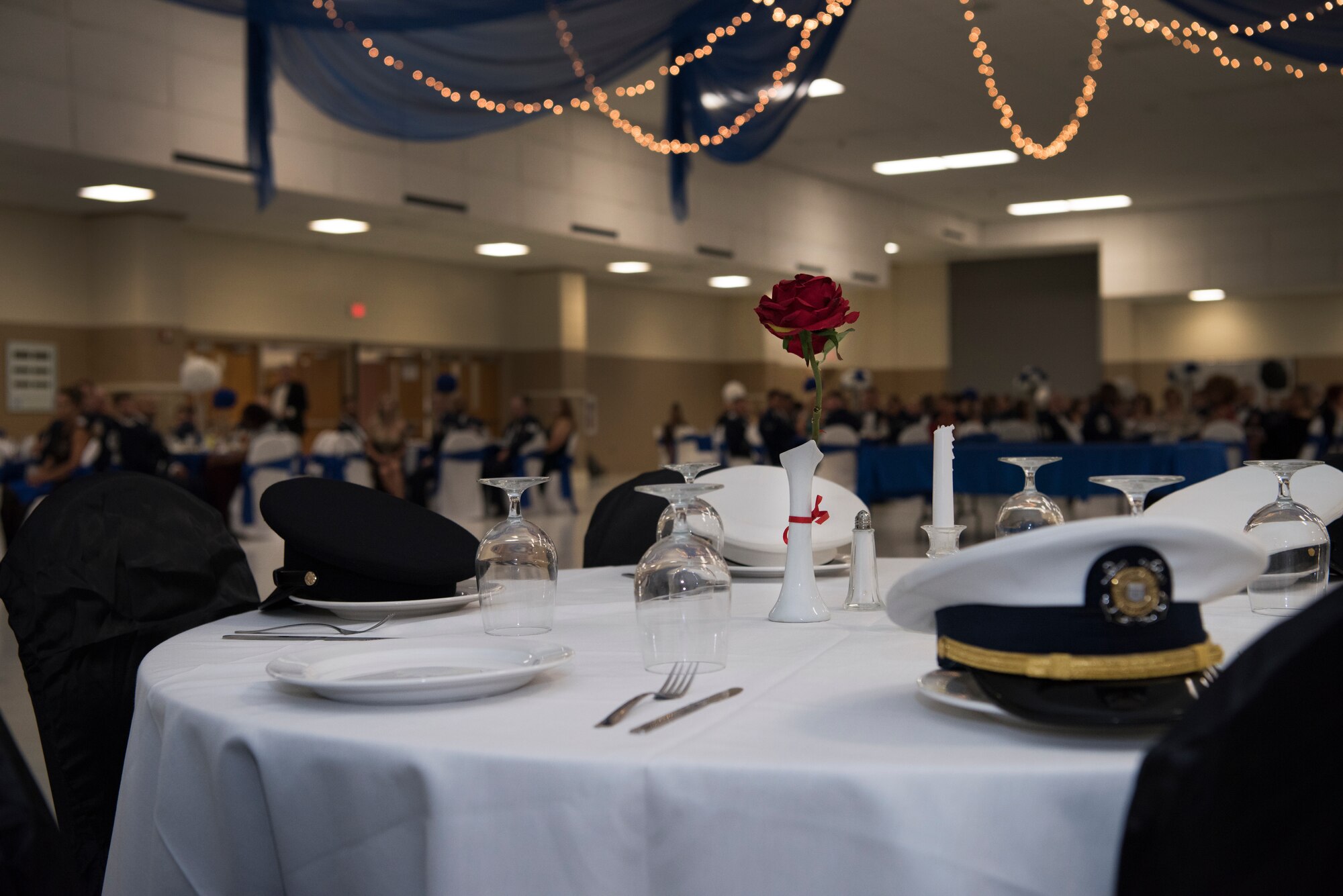Before festivities began, Airmen assigned to the 47th Flying Training Wing set a table dedicated to America’s POW/MIA at Laughlin’s Air Force Ball in Del Rio, Texas, Sept. 13, 2019. At nearly every wing level celebration, time is carved out to remember those who couldn’t be in attendance, and an empty table is ceremoniously set in their honor. (U.S. Air Force photo by Staff Sgt. Benjamin N. Valmoja)