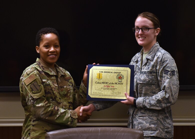 U.S. Air Force Col. Lauren Byrd, 17th Medical Group commander, presents Senior Airman Tiffany Jordan, 17th Healthcare Operations Squadron medical technician, with the Medic of the Month award at the Ross Clinic on Goodfellow Air Force Base, Texas, September 9, 2019. Jordan was a key player in the Medical Group’s Squadron reorganization and was pivotal in realigning positions and key staff assignments. (U.S. Air Force photo by Senior Airman Seraiah Wolf/Released)