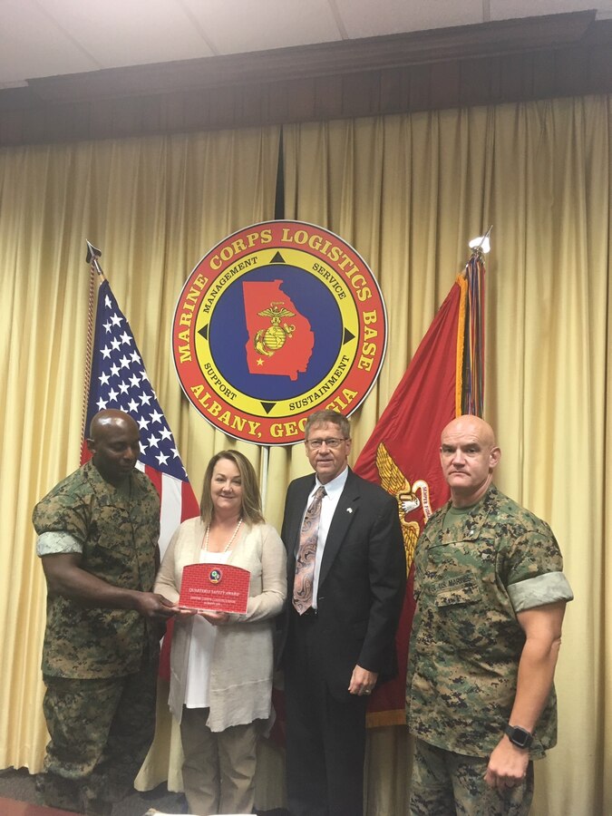 Marine Corps Logistics Base Albany Executive Officer Lt. Col. Joseph Ray, Executive Director Leonard Housley and Sgt. Maj. Jeffrey Young present CISD Director, Dr. Lori Farr, with the Quarterly Safety award during the Commanding Officer's Safety Council, Aug. 7. (U.S. Marine Corps photo by Juan Escovar)