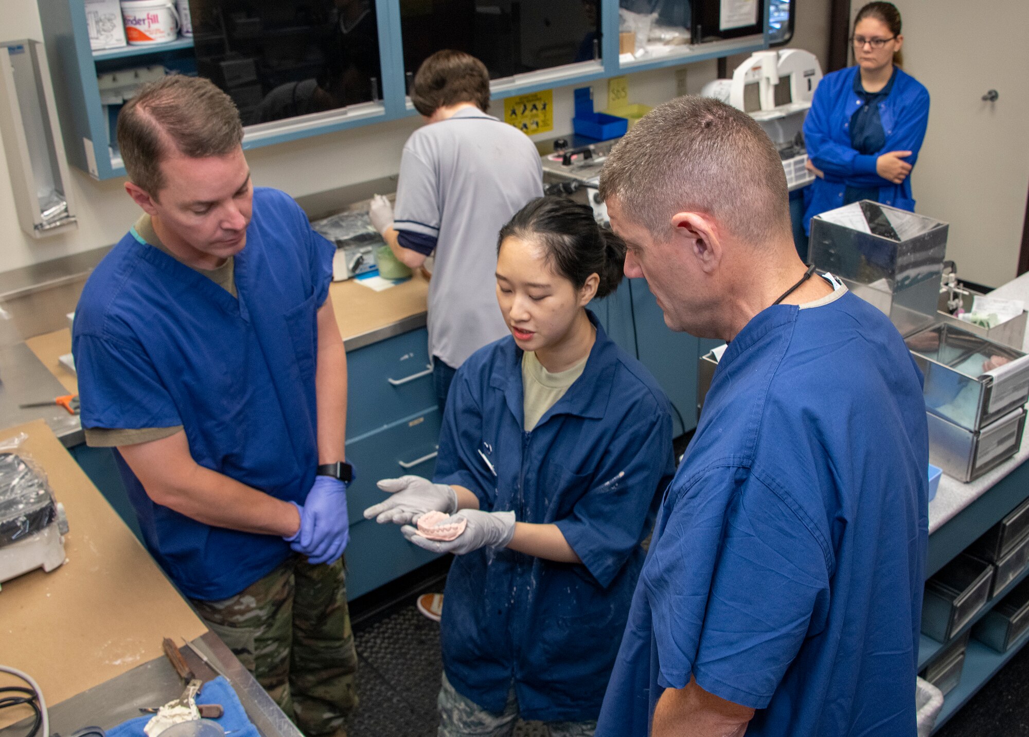 U.S. Air Force Col. Jeffrey Nelson, left, 60th Air Mobility Wing commander, and Chief Master Sgt. Derek Crowder, 60th AMW command chief, listen to Senior Airman Sooa Choi, center, 60th Dental Squadron dental laboratory technician, explain the procedure of creating a mold from a dental impression as part of Leadership Rounds Sept. 13, 2019, at David Grant USAF Medical Center, Travis Air Force Base, California. The Leadership Rounds program involves wing leadership interacting with Airmen to get a detailed view of each mission performed at Travis AFB. (U.S. Air Force photo by Heide Couch)