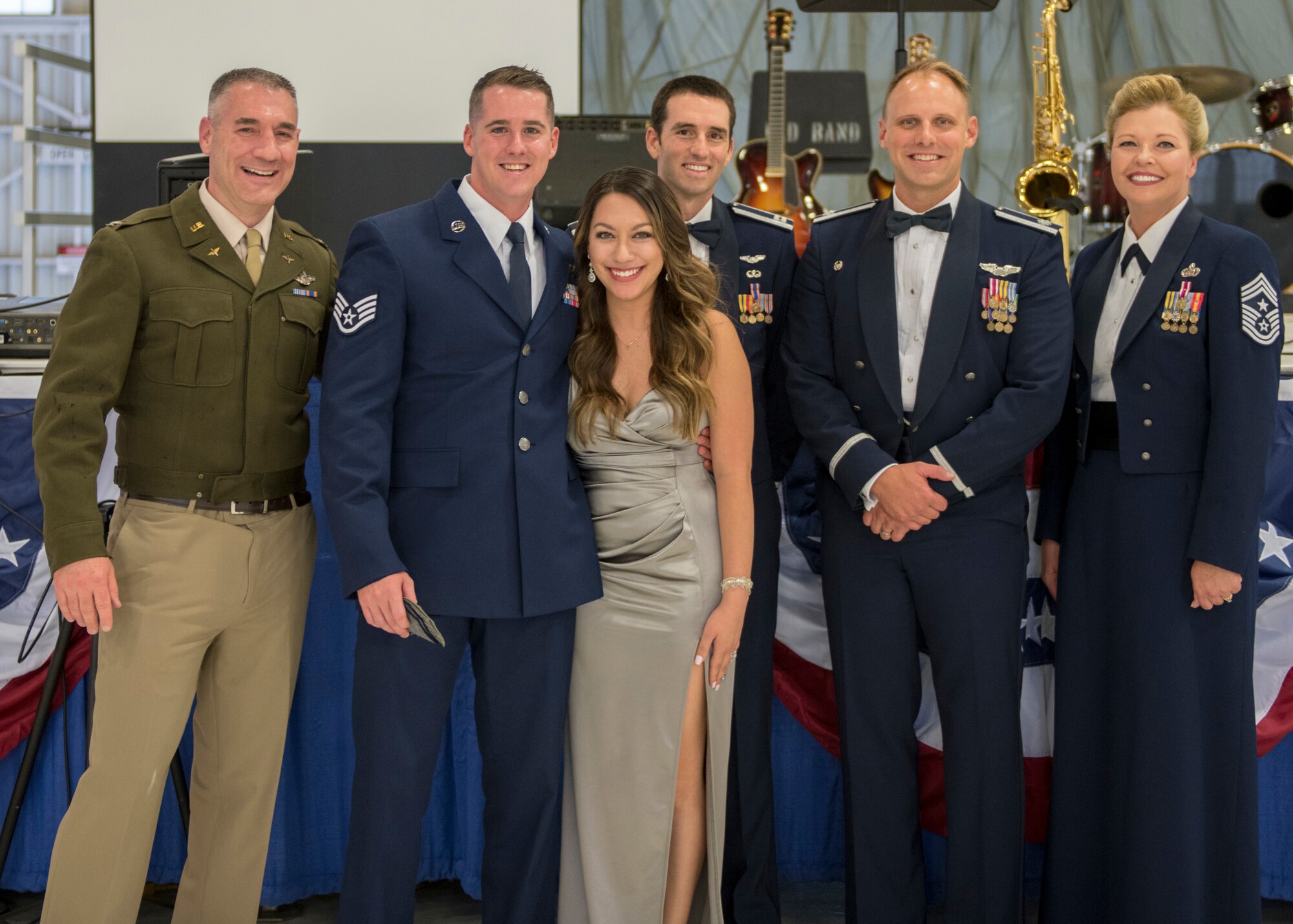 Newly promoted Tech. Sgt. Kyle Saxon, 54th Operations Support Squadron operations flight chief, poses for a photo with his spouse and base leadership at the Air Force Ball, Sept. 14, 2019, on Holloman Air Force Base, N.M. Saxon promoted from staff sergeant to technical sergeant through the Stripes for Exceptional Performers program. (U.S. Air Force photo by Airman 1st Class Kindra Stewart)