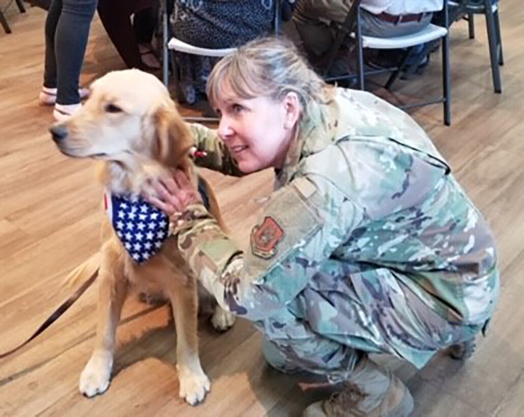 While volunteering for the Wreath Project Sept. 7 at the C.C. Yin Ranch, Senior Master Sgt. Michelle Hammer Coffer made a new furry friend. Micah is a service dog in training, so his harness says “Pet me please,” as socialization is part of his curriculum.