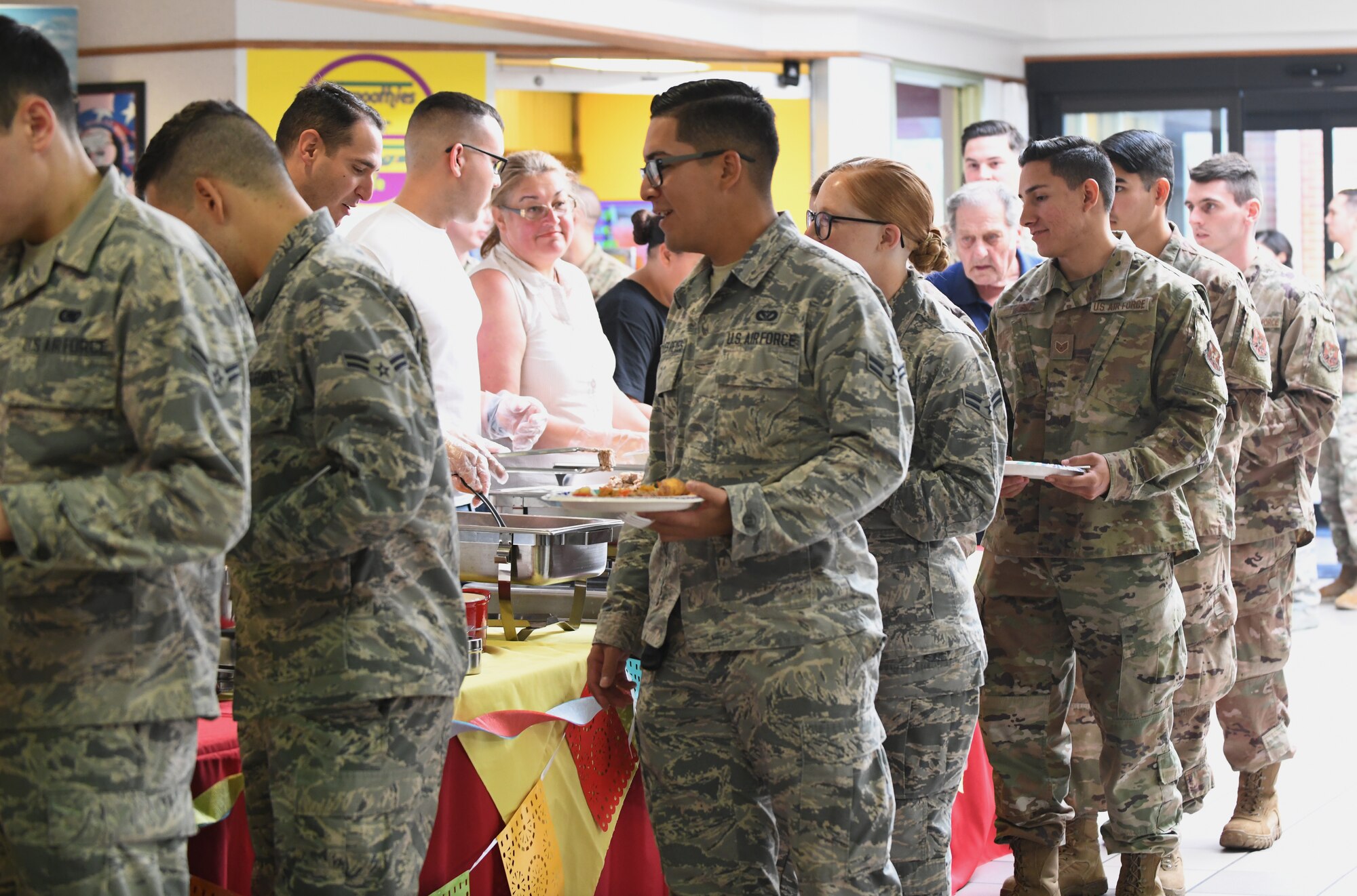 Airmen line up at the ‘Taste of Latin America’ food tasting event, held at the Base Exchange food court, on Ellsworth Air Force Base, S.D., Sept. 16, 2019. The food tasting included authentic dishes from Colombia, Mexico, Cuba and Puerto Rico. The event was hosted and catered by members of the Ellsworth Latin American Community (ELAC). (U.S. Air Force photo by Airman 1st Class Christina Bennett)