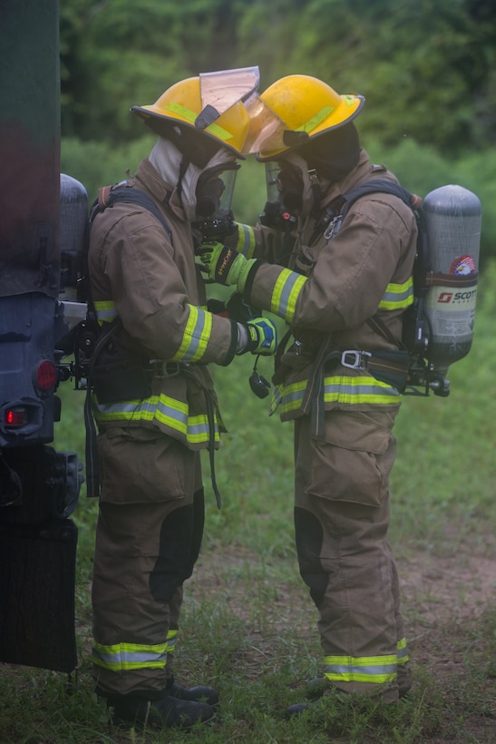 Aircraft Recovery and Fire Fighting (ARFF) Marines put on and adjust their protective gear during an aircraft recovery scenario at Marine Corps Auxiliary Landing Field Bogue, North Carolina, Aug. 16, 2019. ARFF Marines attached to Marine Wing Support Detachment 273 trained to improve readiness, efficiency, and recovery times.