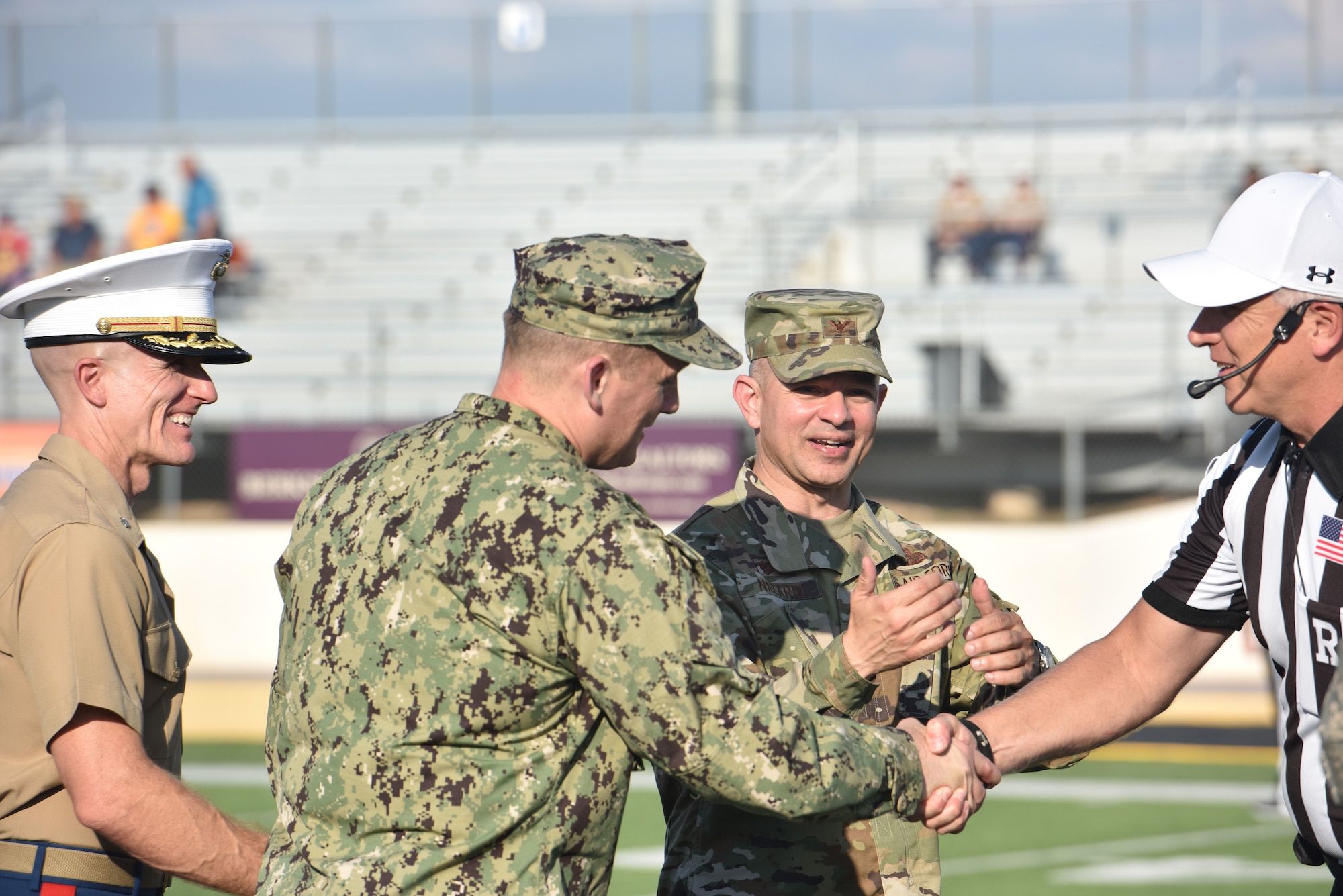 Goodfellow leadership shakes hands with a referee before the start of the Angelo State University vs Simon Fraser University football game which ASU used to host their annual military appreciation night at 1st Community Credit Union Field, San Angelo, Texas, Sept. 14, 2019. U.S. Air Force Col. Andres Nazario, 17th Training Wing commander, presented the game ball to the referee before the start of the game. (U.S. Air Force photo by Senior Airman Seraiah Wolf/Released)