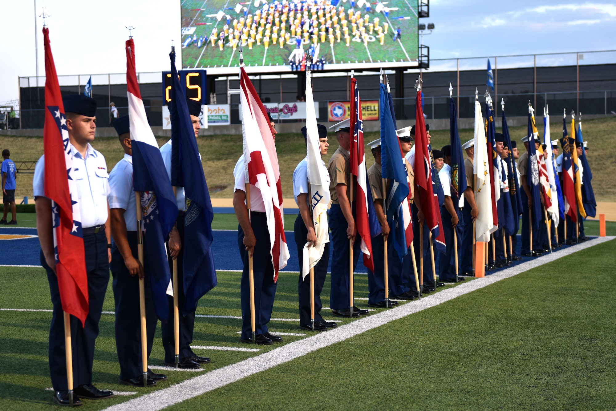 Goodfellow military members display the fifty state flags during halftime at the Angelo State University vs Simon Fraser game as a part of military appreciation night on the 1st Community Credit Union Field, San Angelo, Texas, Sept. 14, 2019. During the halftime show there was a presentation of the fifty state flags, swearing in of individuals waiting to go to basic training and the Goofellow Honor Guard presented the colors. (U.S. Air Force photo by Senior Airman Seraiah Wolf/Released)