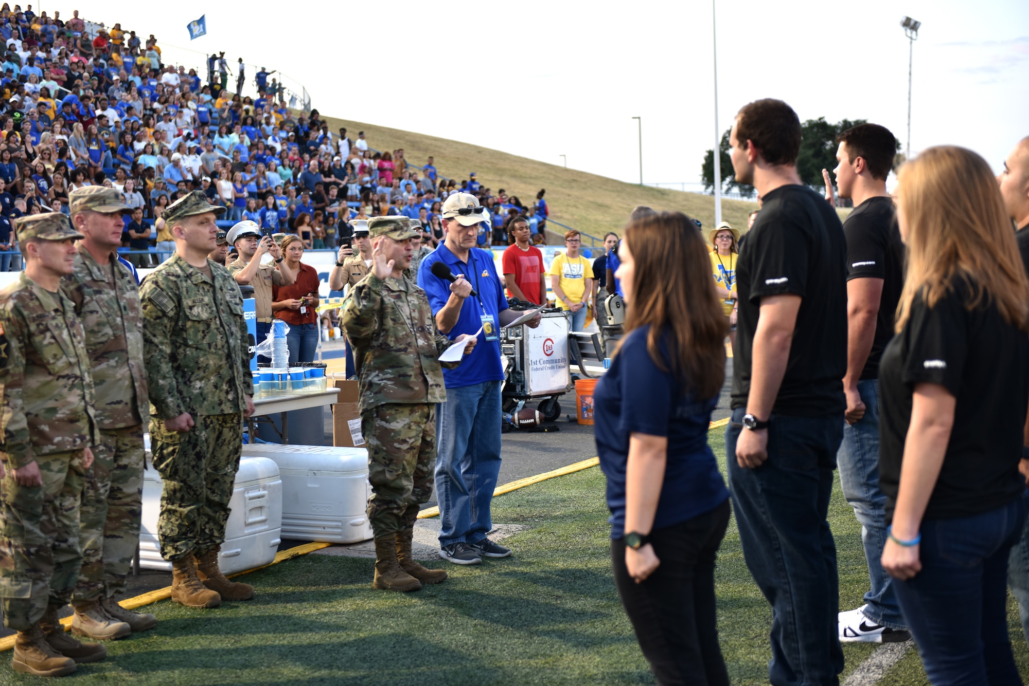 U.S. Air Force Col. Andres Nazario, 17th Training Wing commander, performs the oath of enlistment during the halftime show of the Angelo State University vs Simon Fraser University game at the 1st Community Credit Union Field, San Angelo, Texas, Sept. 14, 2019. ASU held their annual military appreciation night where military members and their famlies could attend the game. (U.S. Air Force photo by Senior Airman Seraiah Wolf/Released)