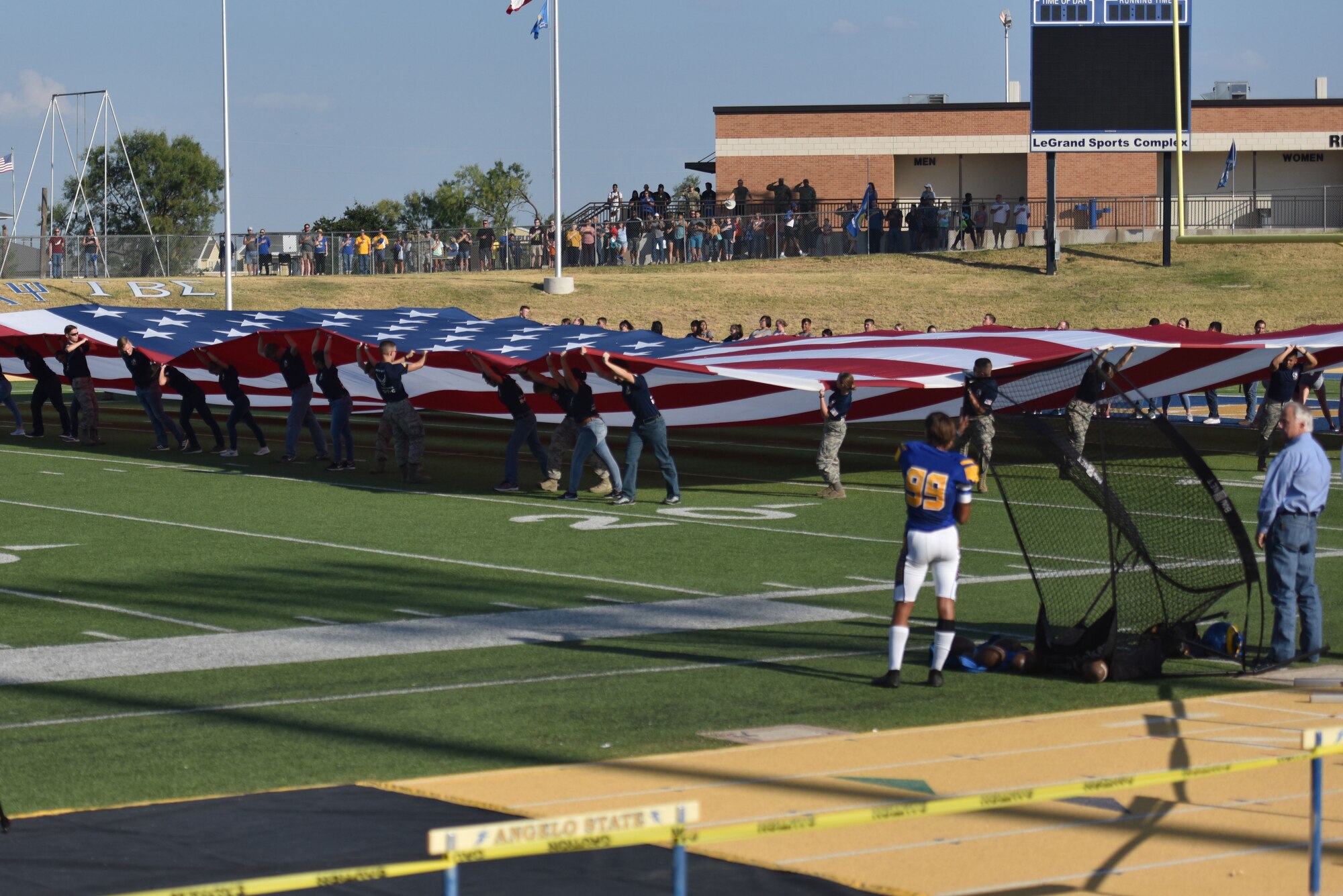 Angelo State University Reserve Officer Training Corps cadets display a flag during the singing of the National Anthem to begin the ASU vs Simon Fraser University game at 1st Community Credit Union Field, San Angelo Texas, Sept. 14, 2019. ROTC is a college and university based program for training cadets to commission into the U.S. Armed Forces. (U.S. Air Force photo by Senior Airman Seraiah Wolf/Released)