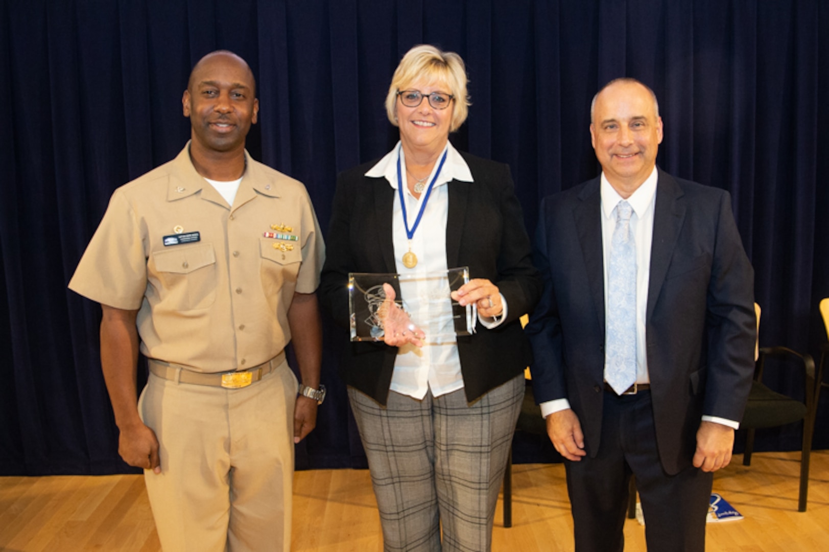 Chief of Staff Kathy Stanley receives the Vice Adm. Samuel Gravely Award during the Naval Surface Warfare Center, Carderock Division Honor Awards on Sept. 10, 2019, in West Bethesda, Md. With Stanley is Commanding Officer Capt. Cedric McNeal and Technical Director Larry Tarasek. (U.S. Navy photo by Nicholas Brezzell/Released)