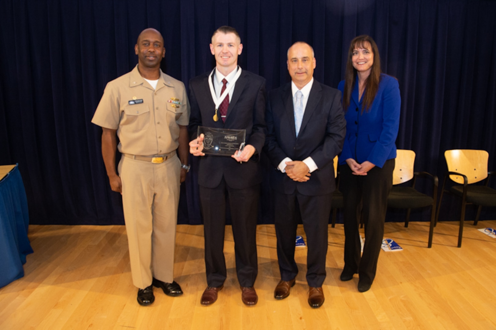 Luke Van Buskirk, deputy head for the Corporate Operations (Property) Department, receives the Rear Adm. Grace Hopper Award the Naval Surface Warfare Center, Carderock Division Honor Awards on Sept. 10, 2019, in West Bethesda, Md. With Van Buskirk is Commanding Officer Capt. Cedric McNeal, Technical Director Larry Tarasek and Corporate Operations Department Head Tamar Gallagher. (U.S. Navy photo by Nicholas Brezzell/Released)