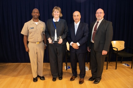 Dr. Maureen Foley, Composites Team lead, receives the Rear Adm. Benjamin Isherwood Award the Naval Surface Warfare Center, Carderock Division Honor Awards on Sept. 10, 2019, in West Bethesda, Md. With Foley is Commanding Officer Capt. Cedric McNeal, Technical Director Larry Tarasek and Platform Integrity Department Head Jeff Mercier. (U.S. Navy photo by Nicholas Brezzell/Released)