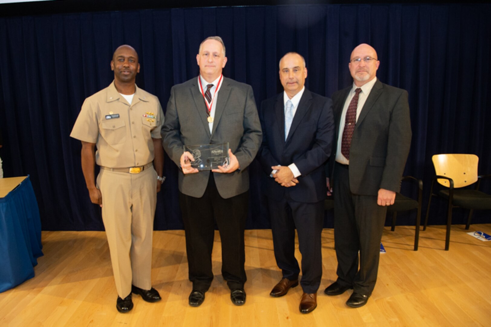 Paul Young, program and engineering manager for Columbia and Virginia pressure hull model programs, receives the Rear Adm. George Melville Award the Naval Surface Warfare Center, Carderock Division Honor Awards on Sept. 10, 2019, in West Bethesda, Md. With Young is Commanding Officer Capt. Cedric McNeal, Technical Director Larry Tarasek and Platform Integrity Department Head Jeff Mercier. (U.S. Navy photo by Nicholas Brezzell/Released)
