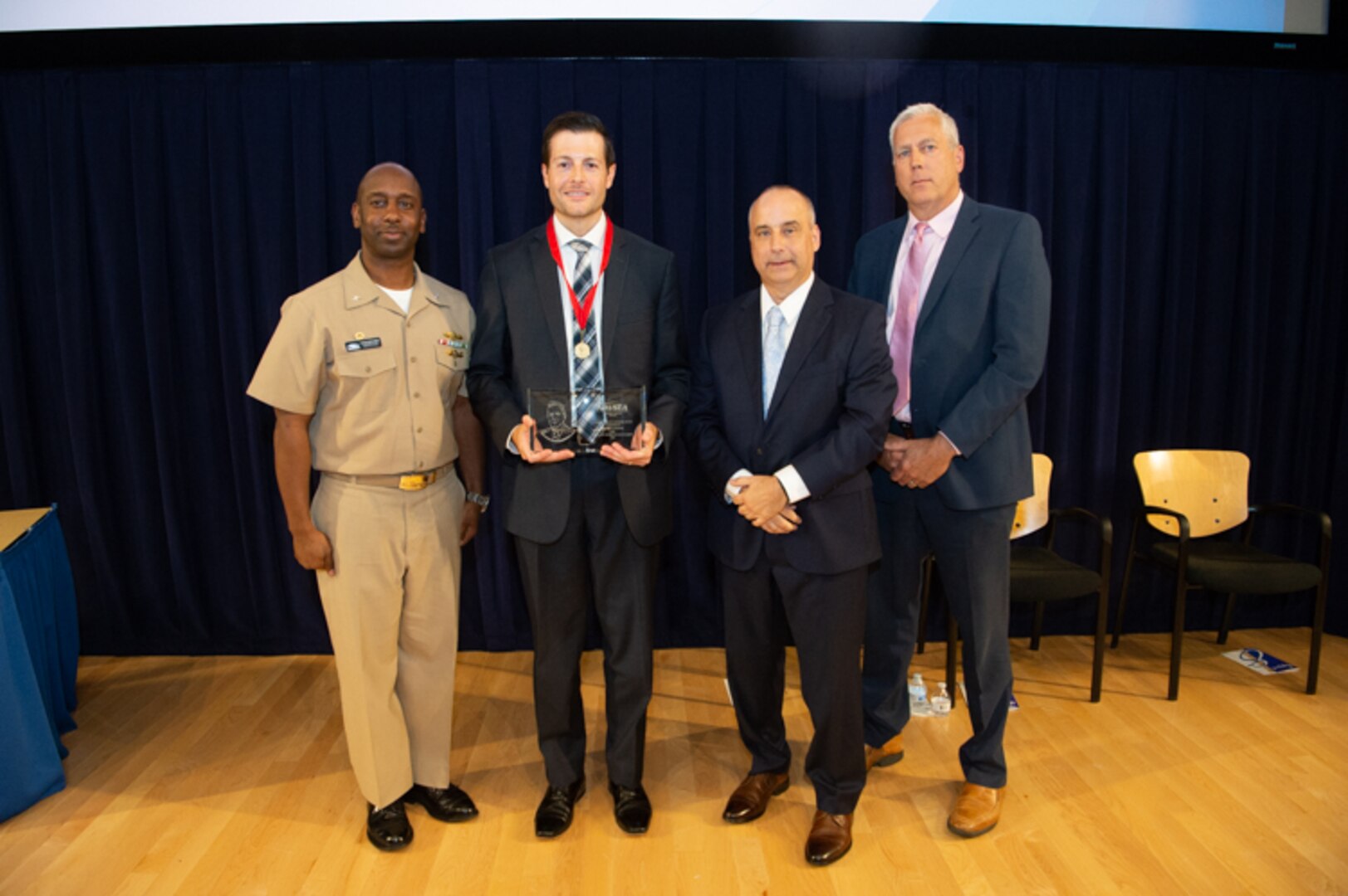 Bradley Schafer, head of the Columbia-class Submarine Management Branch, receives the Capt. Harold Saunders Award the Naval Surface Warfare Center, Carderock Division Honor Awards on Sept. 10, 2019, in West Bethesda, Md. With Schafer is Commanding Officer Capt. Cedric McNeal, Technical Director Larry Tarasek and Naval Architecture and Engineering Department Head Mike Brown. (U.S. Navy photo by Nicholas Brezzell/Released)