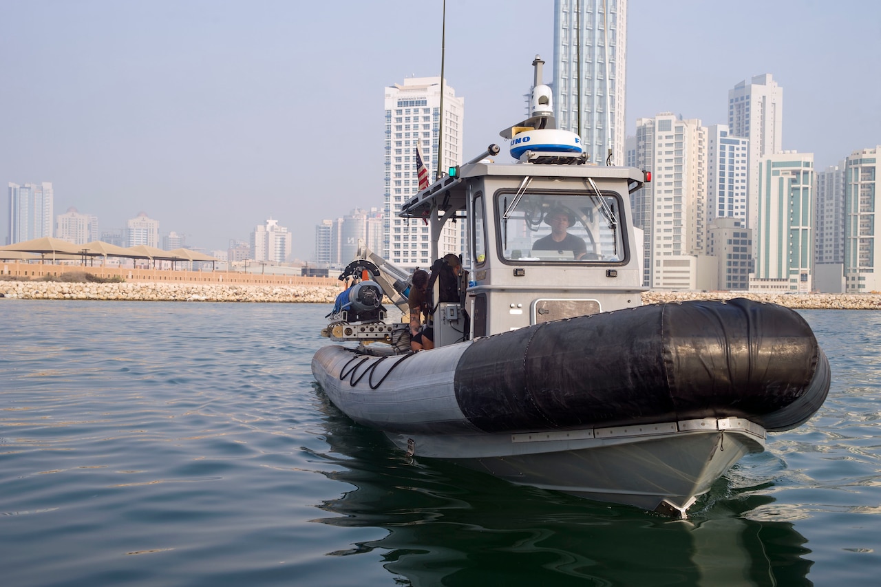 A small boat sails near city.