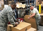 Air Force Master Sgt. Brian Swayne and Army Capt. Garland Fleming II, both DLA Land and Maritime reservists, pack and mark bare items as part of an effort to reduce suspended stock at DLA Distribution warehouses. Courtesy photo