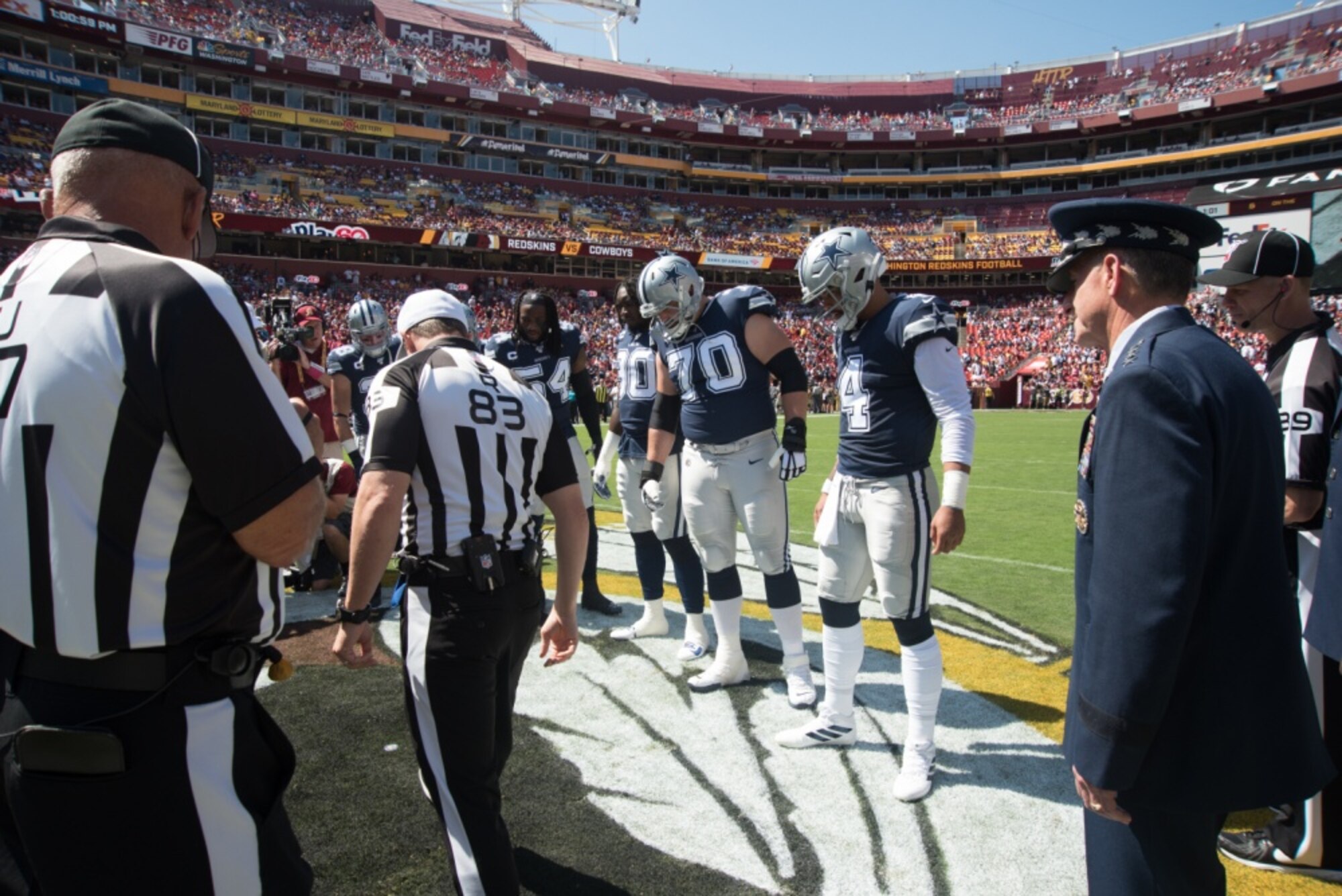A referee reviews the coin toss at the Washington Redskins vs. Dallas Cowboys game at FedEx Field, September 15, 2019. Air Force Chief of Staff Gen. David L. Goldfein presented his coin for the opening ceremony in honor of the Air Forces 72nd birthday. (U.S. Air National Guard photo by Tech. Sgt. Erica Flores)