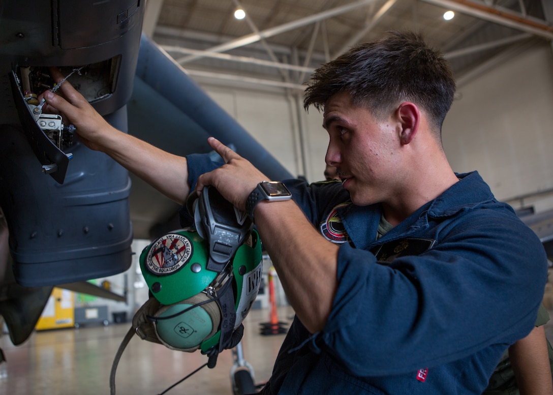 Marine Sgt. Salvatore F. Cuneo, an avionics technician with Marine Attack Training Squadron 203, adjusts wiring inside the fuselage of an T/AV-8B Harrier II prior to it being moved to outside storage at Marine Corps Air Station Cherry Point, North Carolina, Sep. 16, 2019. Marines attached to VMAT-203 execute daily maintenance to ensure dependability of the aircraft as well as the capability for it be ready at any moment’s notice. VMAT-203 is a part of Marine Aircraft Group 14, 2nd Marine Aircraft Wing.  (U.S. Marine Corps photo by Lance Cpl. Elias E. Pimentel III)