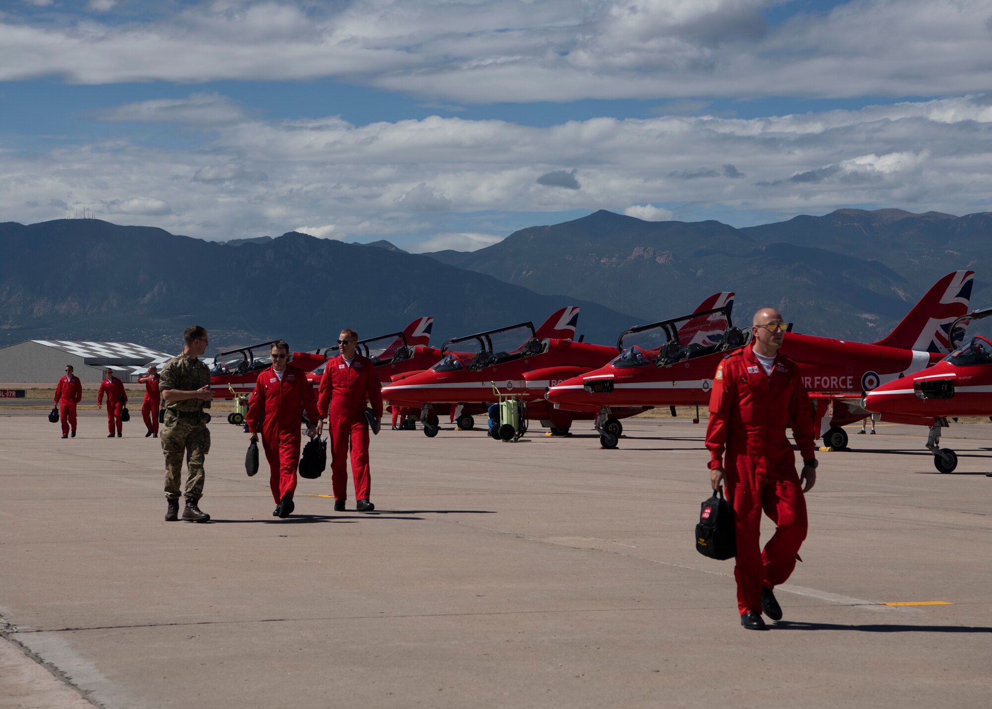 Members of the Royal Air Force aerial demonstration team, the Red Arrows, walk across the Peterson Air Force Base, Colorado, flight line Sept. 16, 2019. The team stopped at Peterson AFB as part of their North American tour. (U.S. Air Force photo by Heather Heiney)