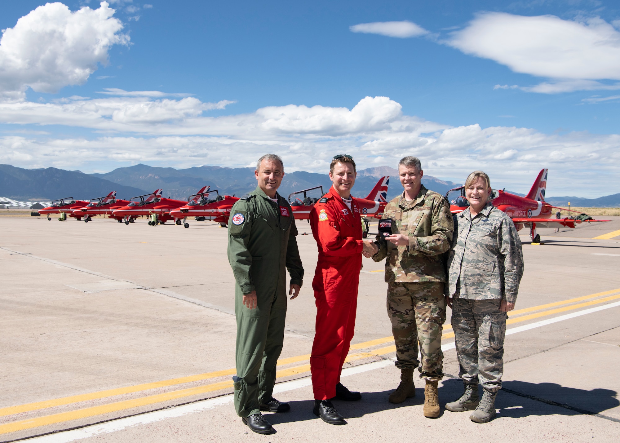 From left, Group Captain Tony Franklin and Wing Commander Andrew Keith, Royal Air Force, present a Red Arrows coin to Col. Sam Johnson, 21st Space Wing vice commander and Col. Jennifer Fitch, individual mobilization augmentee to the 21st Space Wing commander Sept. 16, 2019 at Peterson Air Force Base, Colorado. Keith and Franklin were visiting with the Red Arrows, the Royal Air Force aerial demonstration team during the team’s North American tour. (U.S. Air Force photo by Heather Heiney)