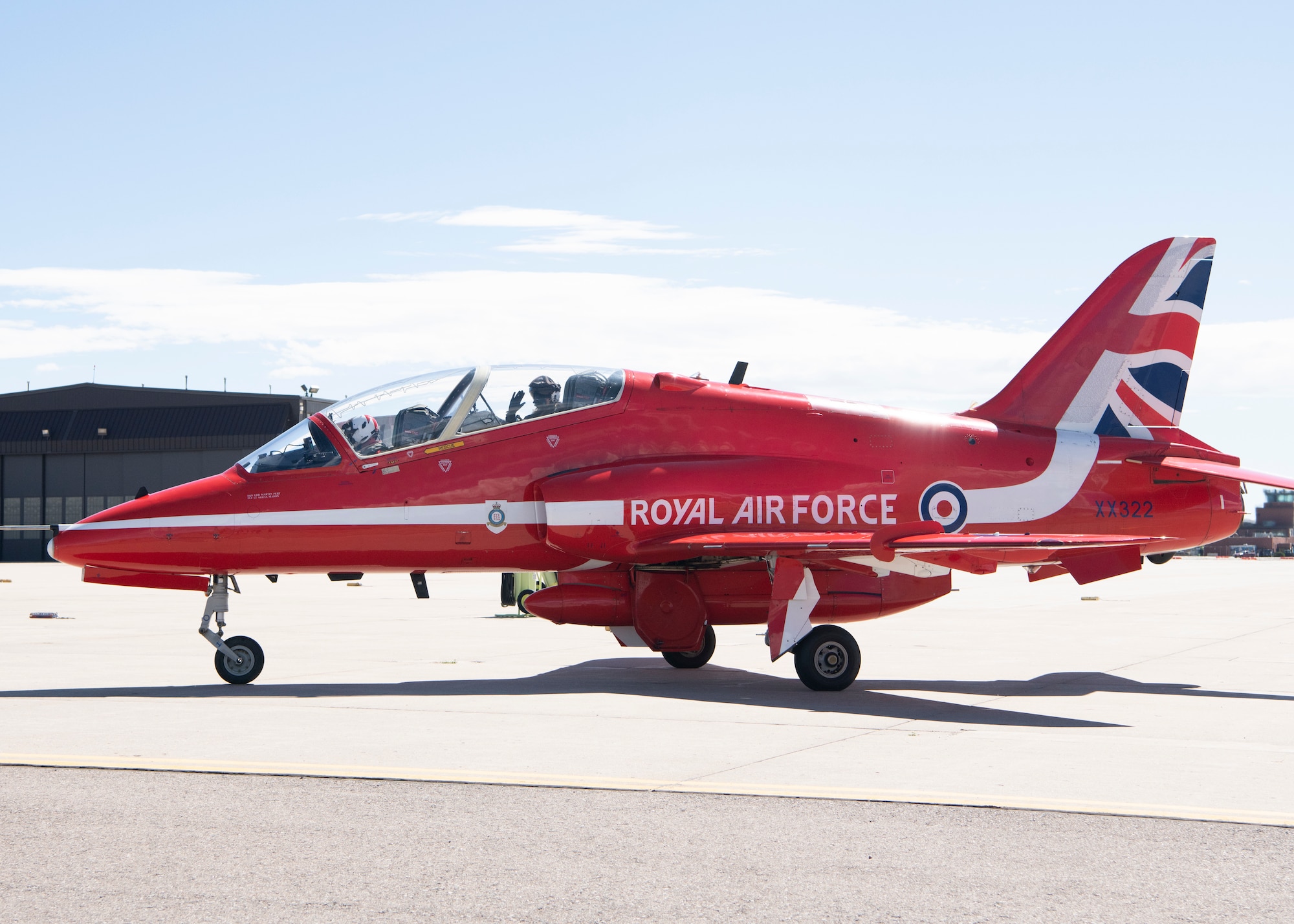 A member of the Royal Air Force demonstration team, the Red Arrows, waves from the cockpit of a Hawk T1 aircraft Sept. 16, 2019 at Peterson Air Force Base, Colorado. The team stopped at the base briefly as part of their North American tour. (U.S. Air Force photo by Heather Heiney)