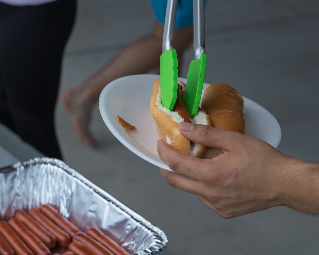 A U.S. Marine prepares a hot dog during the Marine Wing Headquarters Squadron 2 Family Fun Day at Marine Corps Air Station Cherry Point, North Carolina, August 20, 2019. The MWHS-2 Family Fun Day was hosted to give Marines and Sailors some time to meet and build camaraderie throughout the unit. (U.S. Marine Corps photo by Pfc. Steven Walls)