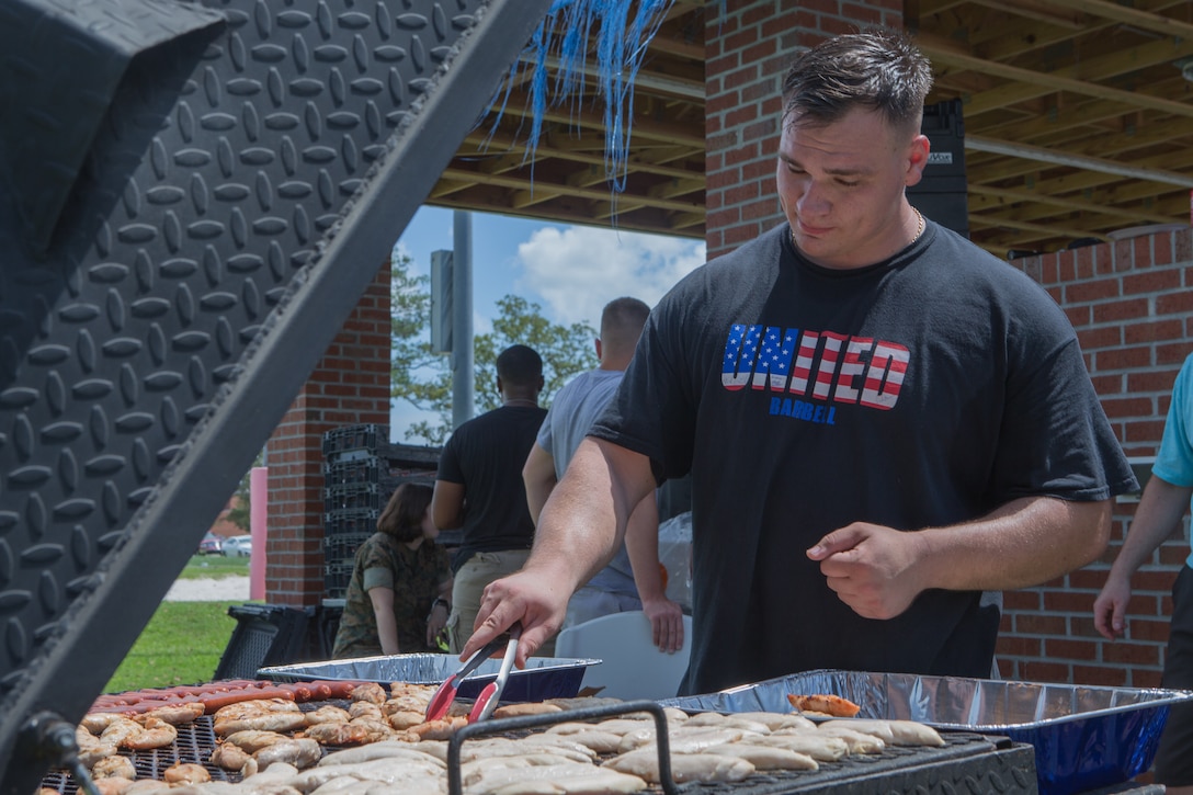 Marine Cpl. Kurt Wuttke grills food during a unit Family Fun Day at Marine Corps Air Station Cherry Point, North Carolina, August 20, 2019. The Family Fun Day was hosted to give Marines and Sailors an opportunity to socialize and build camaraderie throughout the unit.  Cpl. Wuttke is with Marine Wing Headquarters Squadron 2. (U.S. Marine Corps photo by Pfc. Steven Walls)