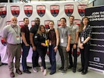 At the 2019 Hack the Machine event held in New York City, Sept. 6-8, members of the first place winning team, "Ahh Ship!" in the educational option of track one, "Hack the Ship," from left to right, Pete Frye, Eric Monette, Emmuel Delgado, Courtnee Mendes, Hanna Salian, Ian Wilson, Chris Draper, and Kiera Wells. The golden water bottle was used in lieu of a trophy.