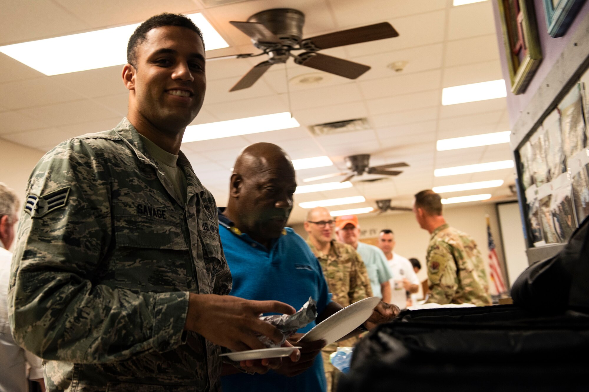 Senior Airman Savage, 23d Civil Engineer Squadron firefighter, smiles while getting food during resiliency training Sept. 10, 2019, at Moody Air Force Base, Ga. The event was hosted by the 23d Wing chaplain, and served as an interactive experience for Airmen, providing practical approaches they can use regularly to improve the resiliency culture in their squadrons. (U.S. Air Force photo by Senior Airman Erick Requadt)