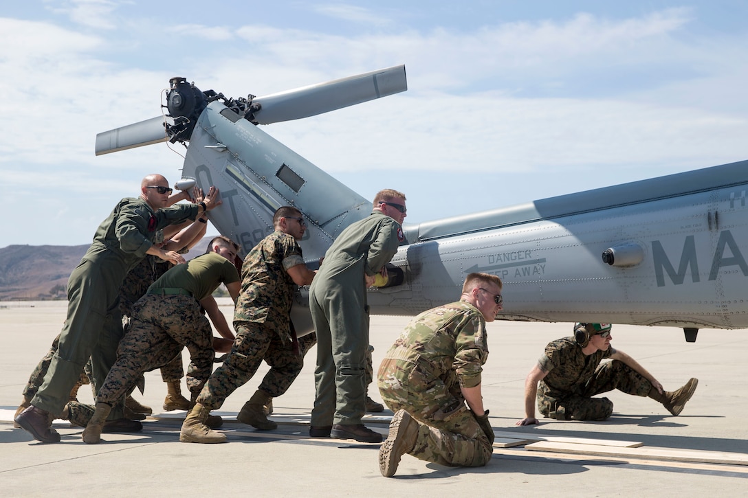 U.S. Marines and airmen assist in loading a UH-1Y Venom into C-5M Super Galaxy at Marine Corps Air Station Camp Pendleton, California, Sept. 16, 2019. The C-5M was a visiting U.S. Air Force aircraft from 433rd Airlift Wing, and was here as part of a dual service training exercise.The air station provides the 1st Marine Expeditionary Force and 3rd Marine Aircraft Wing with flexible deployment options. (U.S. Marine Corps photo by Lance Cpl. Drake Nickels)