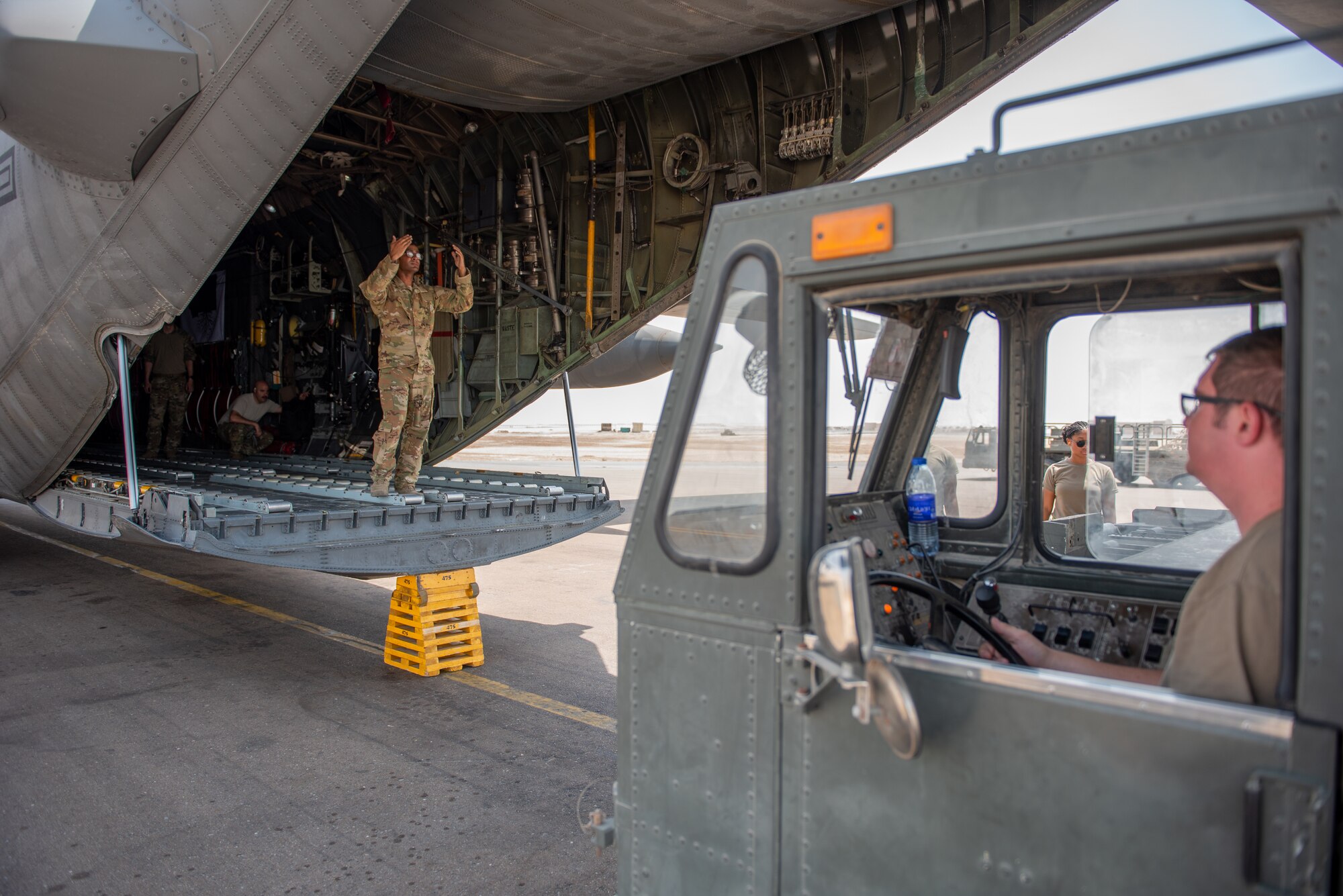 Senior Airman Andrew Williams, 380th Expeditionary Logistics Readiness Squadron air transportation specialist, drives a K-Loader with cargo up to a C-130 Hercules Sept. 17, 2019, at Al Dhafra Air Base, United Arab Emirates. The Air Transportation Operations Center enables Airmen to travel and fulfill duty requirements and taskings throughout the area of responsibility. (U.S. Air Force photo by Staff Sgt. Chris Thornbury)