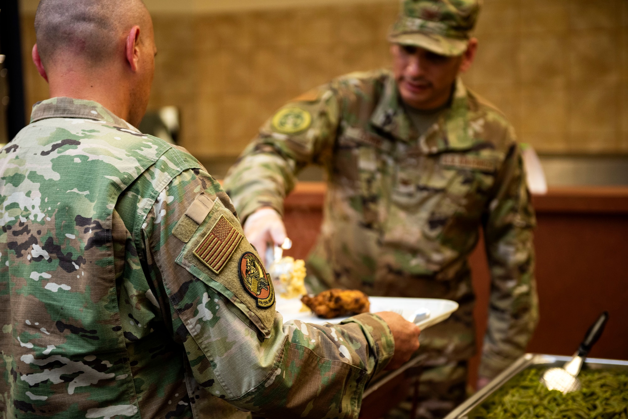 Lt. Col. Eric Rosenlof, 23d Civil Engineer Squadron commander, left, is served food during a Deployed Spouses Dinner Sept. 17, 2019, at Moody Air Force Base, Ga. The monthly event is a free dinner at Georgia Pines Dining Facility designed as a ‘thank you’ for each families’ support and sacrifice. The dinner, occurring on every third Tuesday of the month, provides an opportunity for spouses to interact with other families of deployed Airmen, key spouses and unit leadership, as well as provide a break for the spouse while military sponsor is deployed. The next Deployed Spouses Dinner will be Oct. 15. (U.S. Air Force photo by Senior Airman Erick Requadt)