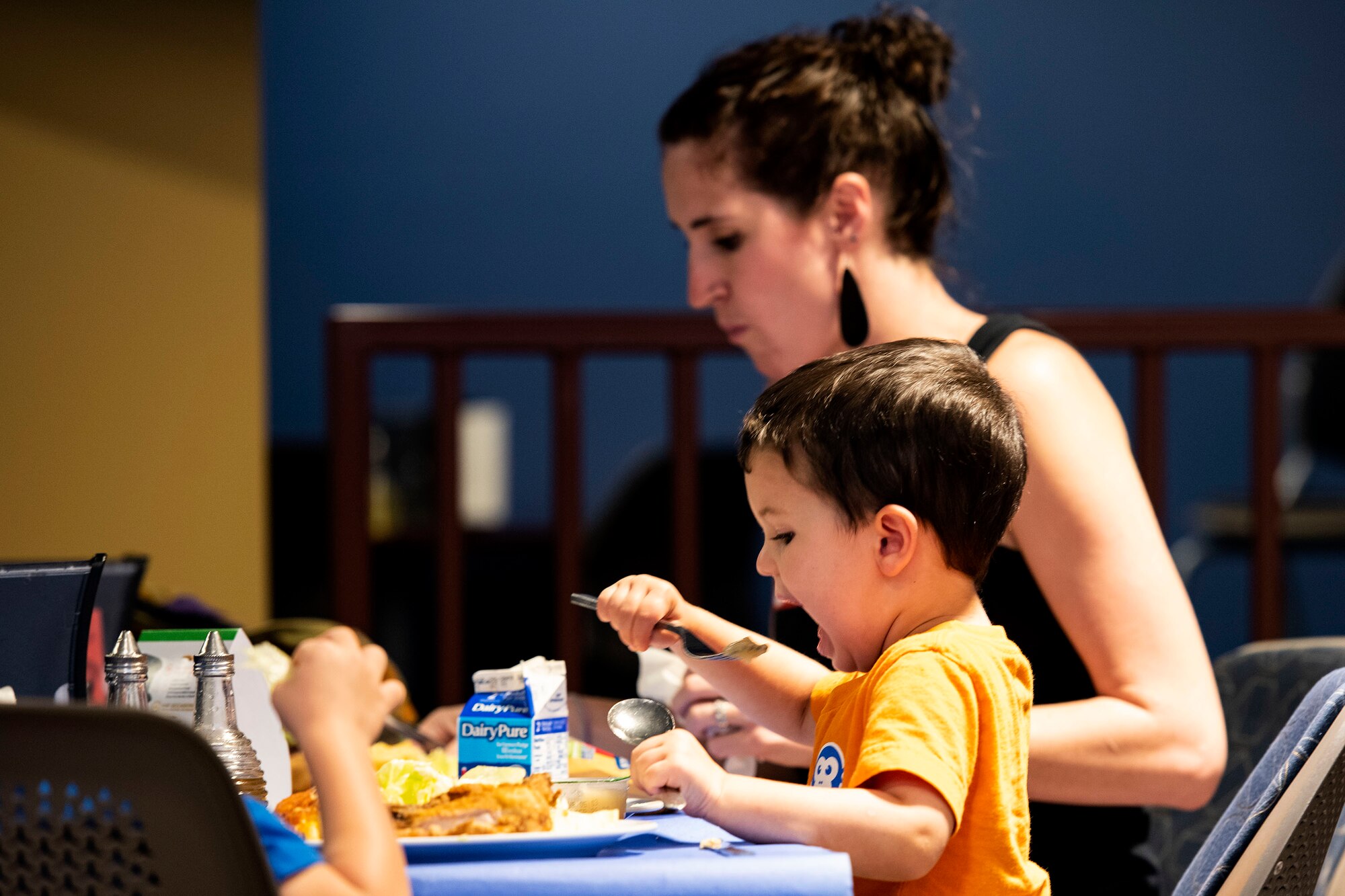 Lauren Barthle, back, military spouse, and her son, Max, eat together during a Deployed Spouses Dinner Sept. 17, 2019, at Moody Air Force Base, Ga. The monthly event is a free dinner at Georgia Pines Dining Facility designed as a ‘thank you’ for each families’ support and sacrifice. The dinner, occurring on every third Tuesday of the month, provides an opportunity for spouses to interact with other families of deployed Airmen, key spouses and unit leadership, as well as provide a break for the spouse while military sponsor is deployed. The next Deployed Spouses Dinner will be Oct. 15. (U.S. Air Force photo by Senior Airman Erick Requadt)