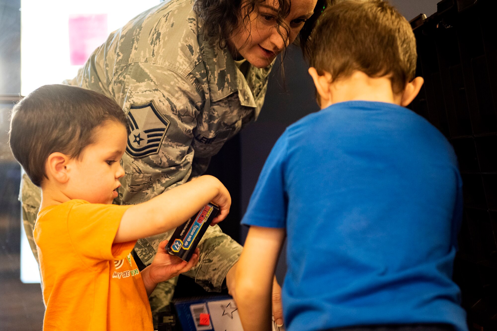 Master Sgt. Amanda Lewis, back, 23d Force Support Squadron NCO in charge of readiness, helps Max, left, and Luke, sons of Laura Barthle, military spouse, pick out toys during a Deployed Spouses Dinner Sept. 17, 2019, at Moody Air Force Base, Ga. The monthly event is a free dinner at Georgia Pines Dining Facility designed as a ‘thank you’ for each families’ support and sacrifice. The dinner, occurring on every third Tuesday of the month, provides an opportunity for spouses to interact with other families of deployed Airmen, key spouses and unit leadership, as well as provide a break for the spouse while military sponsor is deployed. The next Deployed Spouses Dinner will be Oct. 15. (U.S. Air Force photo by Senior Airman Erick Requadt)