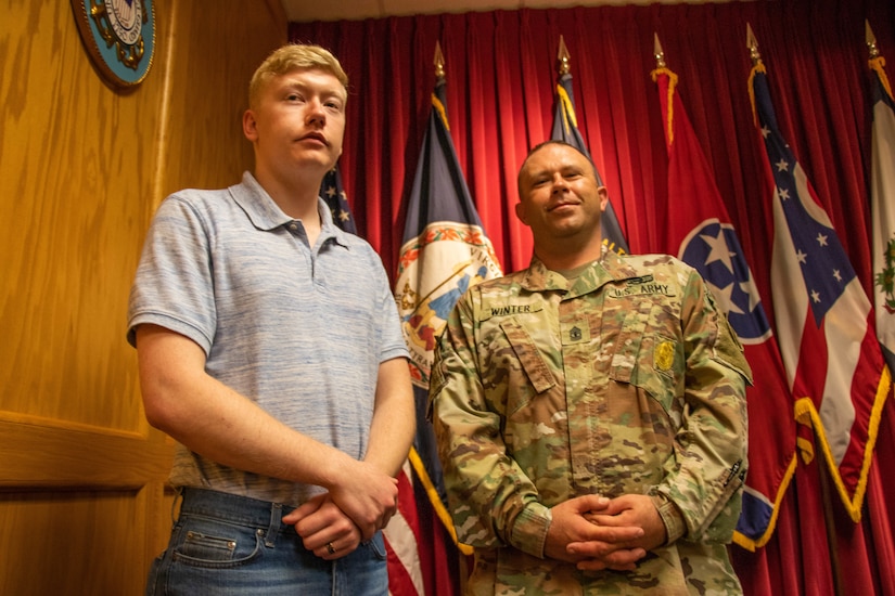 U.S. Army Pvt. 1st Class Michael Winter (left) stands next to father, 1st Sgt. Timothy Winter (right), while he waits to conduct his Oath of Enlistment Sept. 8, 2019 at the Beckley Military Entrance Processing Station, or MEPS, in Beckley, West Virginia. It is at this exact MEPS station where Timothy recited his Oath of Enlistment nearly 20 years ago.