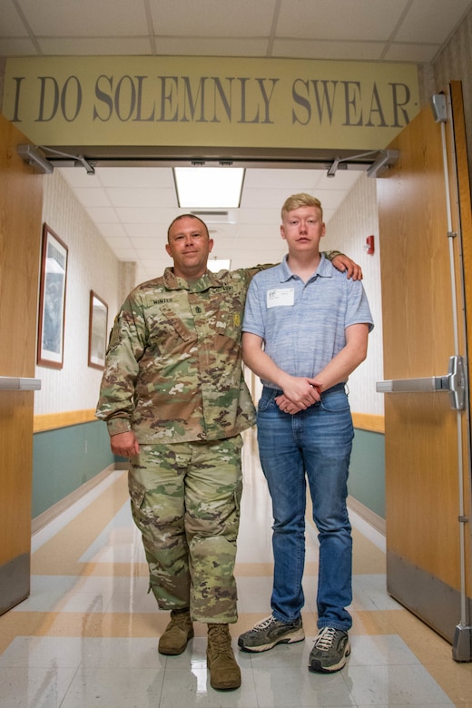 U.S. Army Pvt. 1st Class Michael Winter stands next to father and 1st Sgt. Timothy Winter at MEPS, in Beckley, West Virginia. The Beckley MEPS has overseen the enlistment of thousands of Army Soldiers each year.