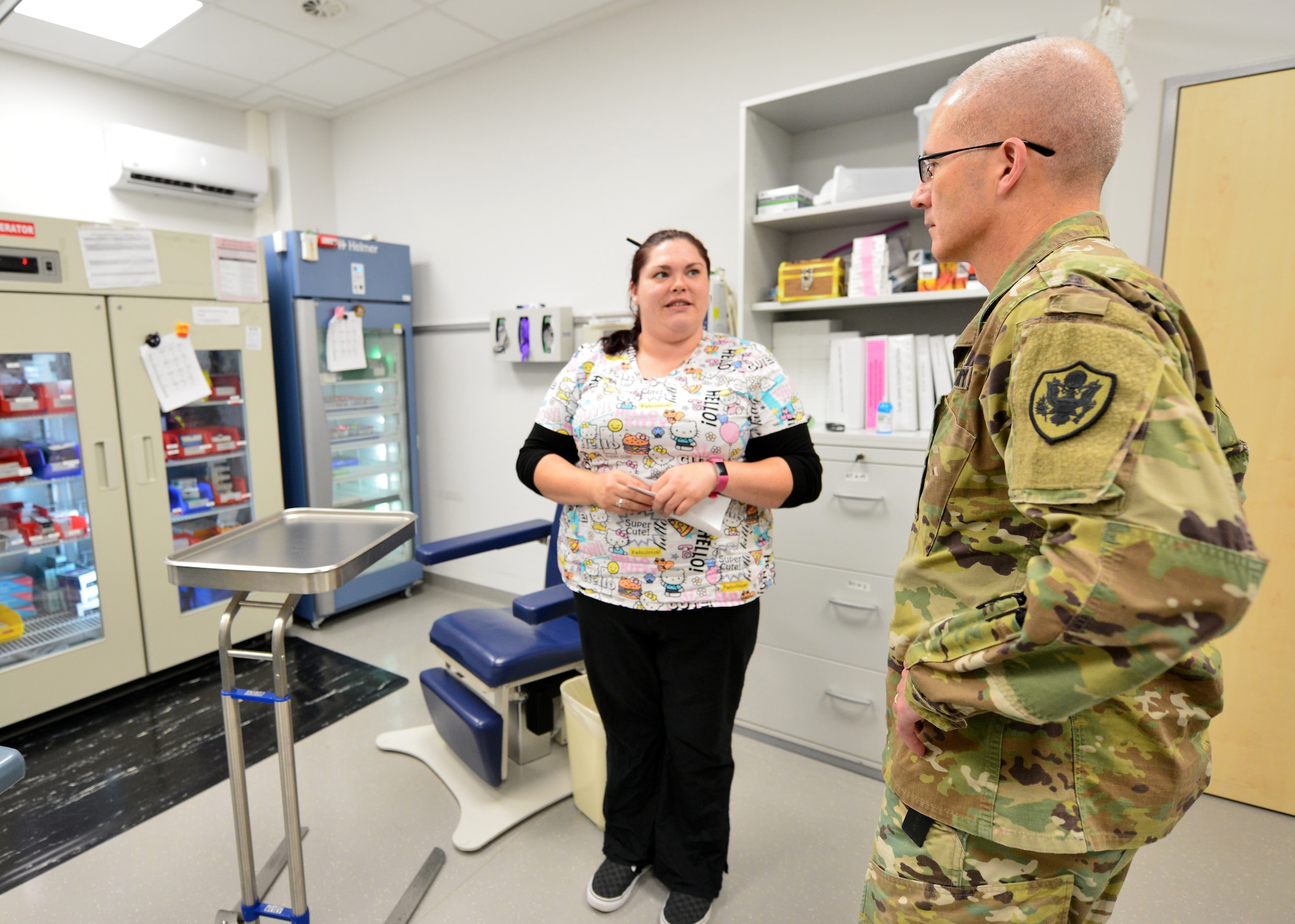 Allison Payne, an Army Nurse with the Stuttgart Army Health Clinic Immunizations Department, provides a mission overview to Lt. Gen. Ronald J. Place, the new Director of the Defense Health Agency, during his visit to Stuttgart on Sept. 11. Place was the Keynote Speaker at the TRICARE Eurasia Africa Commanders and Stakeholders Meeting at Sembach Kaserne, Germany, Sept 9-13. During the visit, he also met with senior military leaders and Surgeons General from Unified Combatant Commands. (Courtesy photo)