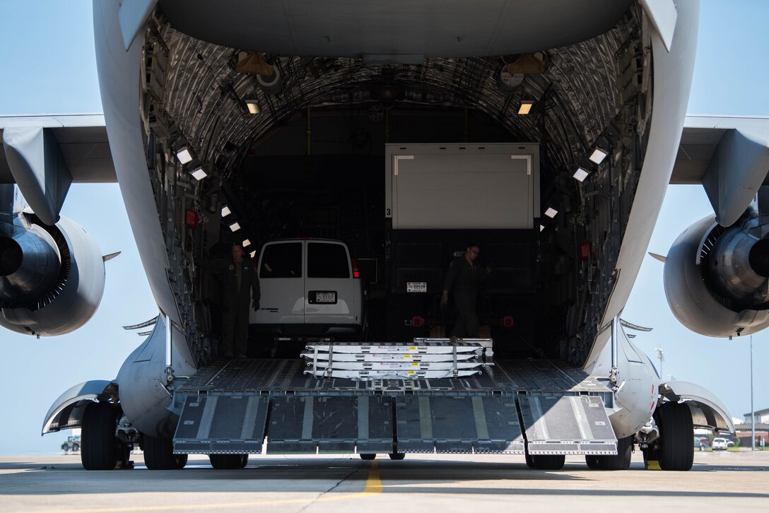 Crew members for a U.S. Air Force C-17 Globemaster III from the Mississippi Air National Guard’s 172nd Airlift Wing, prepare cargo for a flight to Richmond, Virginia during a Joint Task Force Civil Support exercise at Joint Base Langley-Eustis, Virginia, Sept 11. 2019. The C-17 transported vehicles from JBLE to Richmond, Virginia as part of a joint training exercise coordinated between the Air Force, Army, and Navy. (U.S. Air Force photo by Airman 1st Class Marcus M. Bullock)