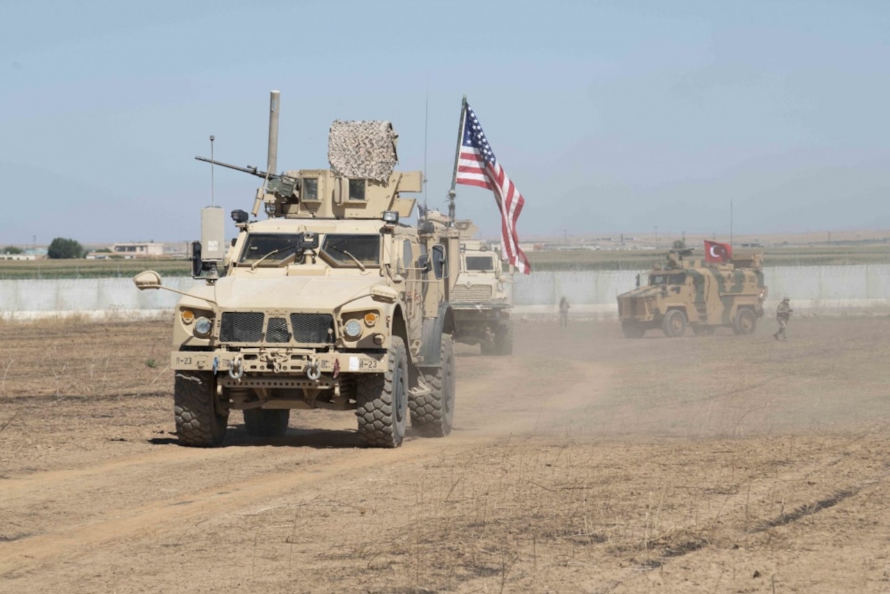 A military vehicle driving through desert.