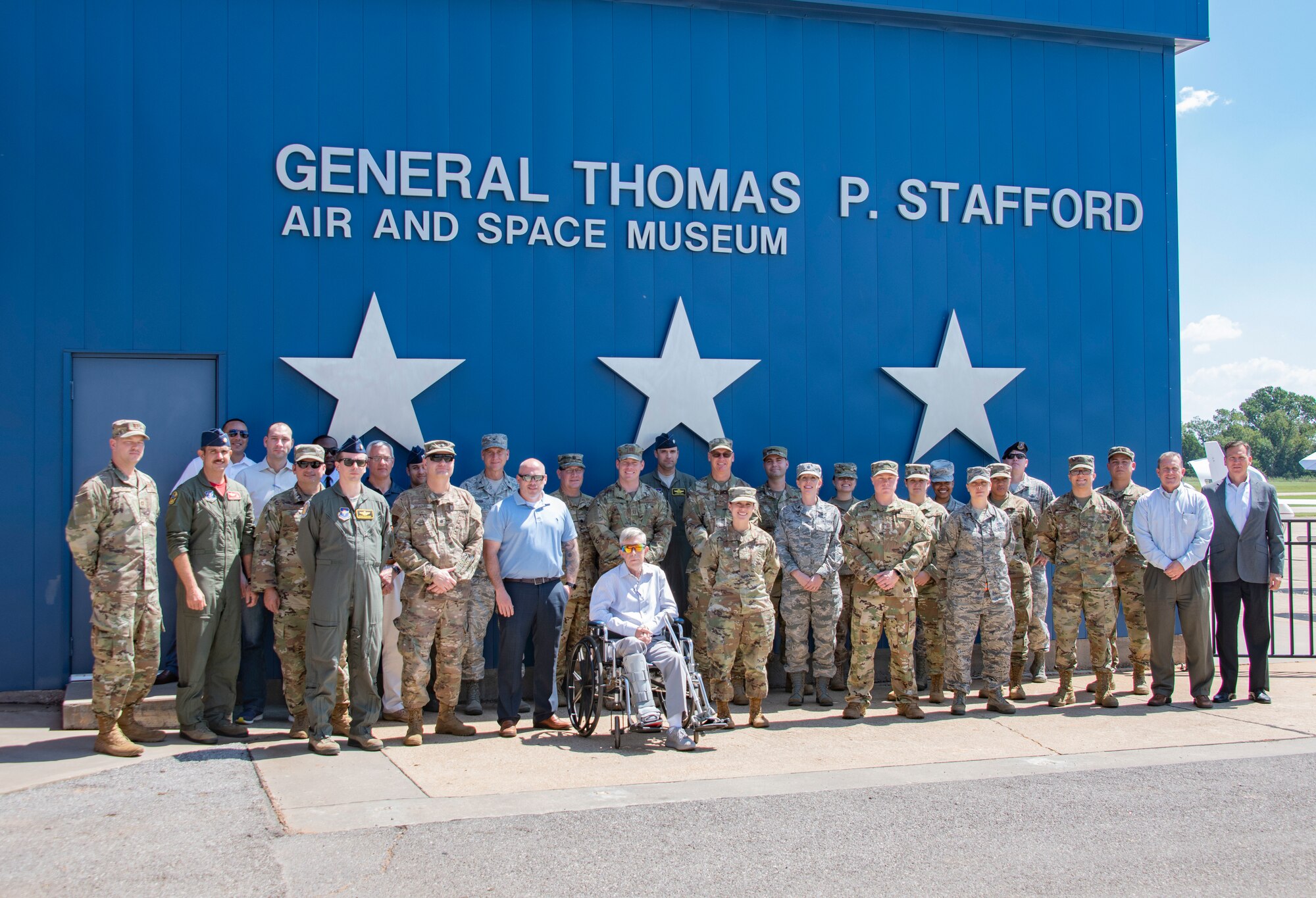Attendees of the joint IG Professional Development seminar stand in front of the buildings sign