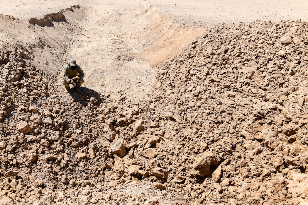 Staff Sgt. Jordan Jones, 56th Civil Engineer Squadron Explosive Ordnance Disposal team member, assigned to Luke Air Force Base, Ariz., inspects the aftermath of an explosion Sept. 12, 2019, at the Barry M. Goldwater Range near Gila Bend, Ariz.