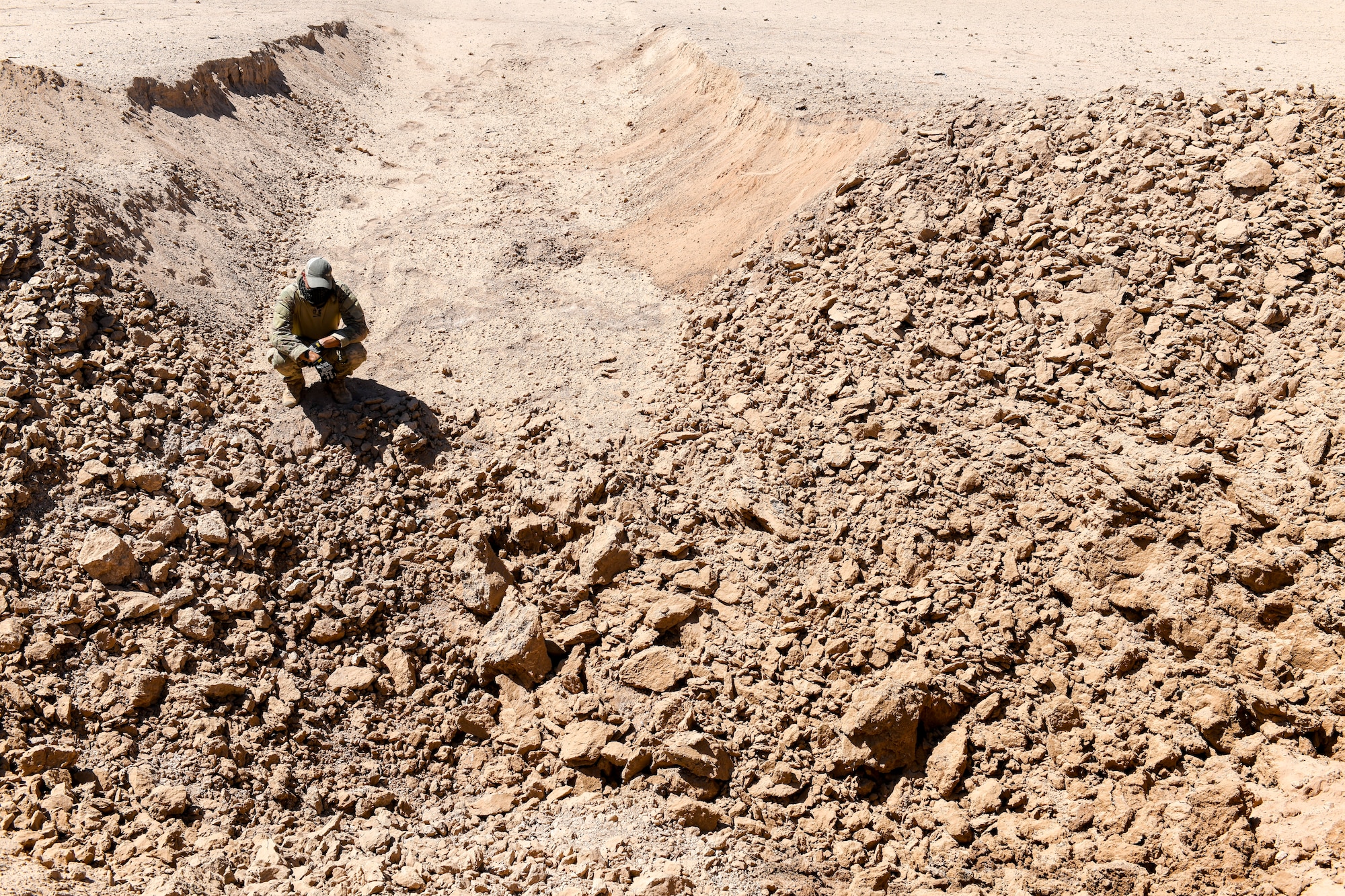 Staff Sgt. Jordan Jones, 56th Civil Engineer Squadron Explosive Ordnance Disposal team member, assigned to Luke Air Force Base, Ariz., inspects the aftermath of an explosion Sept. 12, 2019, at the Barry M. Goldwater Range near Gila Bend, Ariz.